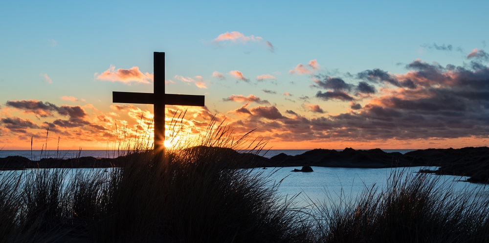 Sunset on lake with cross
